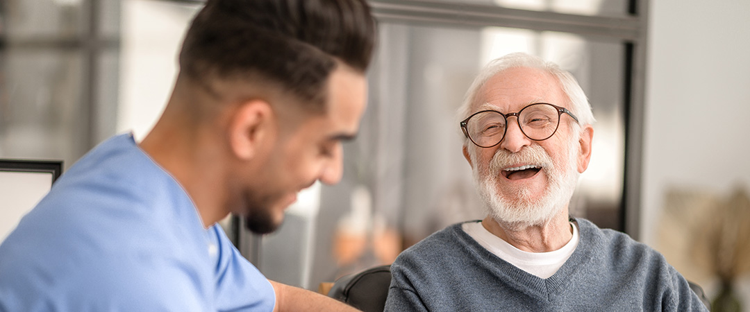 Male nurse and male resident enjoying a laugh together