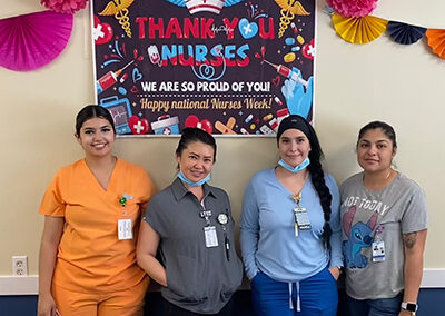 Four nurses standing in front of a sign that says thank you nurses at Willows Post Acute